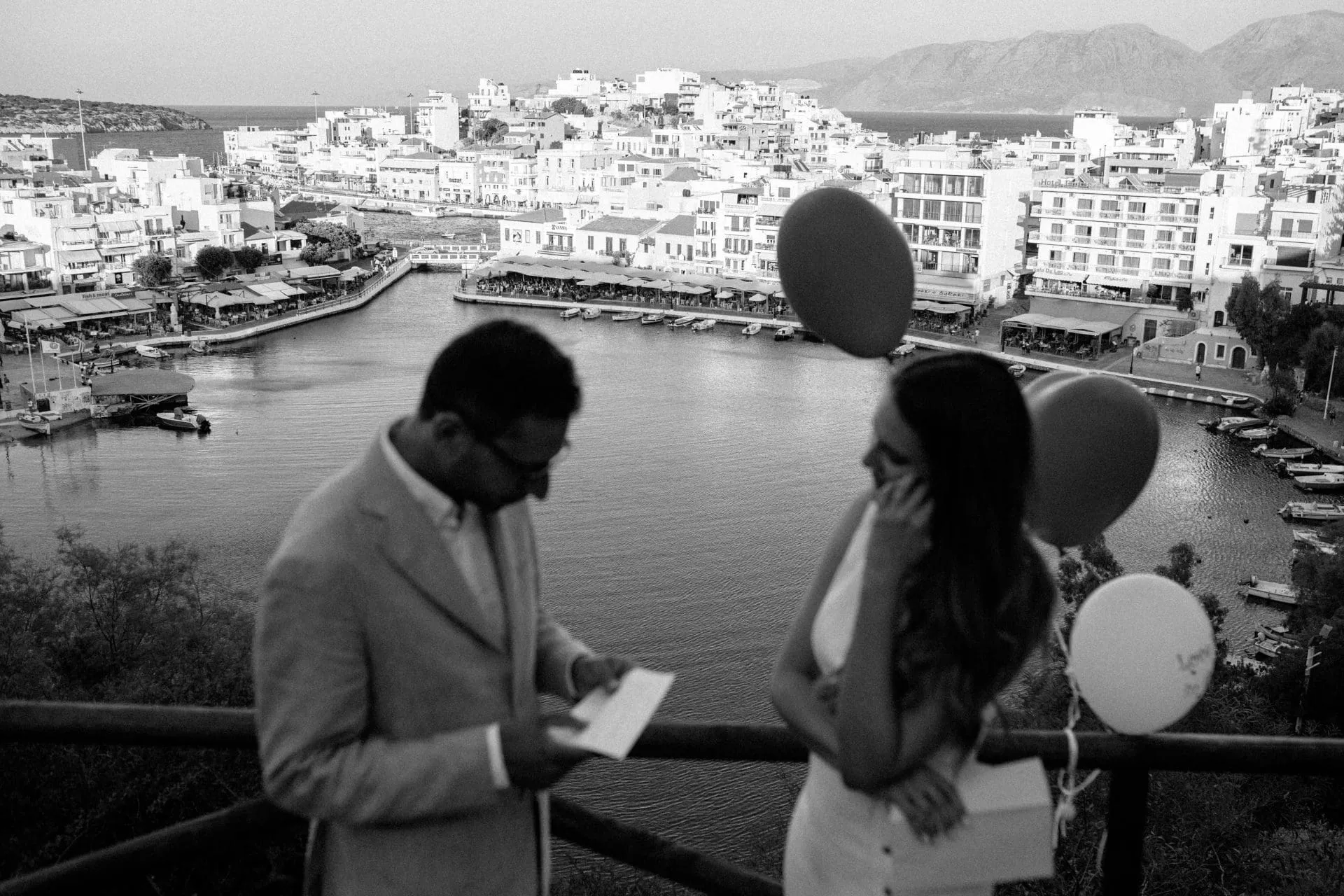 Couple with balloons above the harbour town of Agios Nikolaos — Manos & Karla wedding gallery